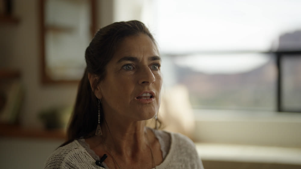 A homeowner mid-sentence during an interview in her own living room